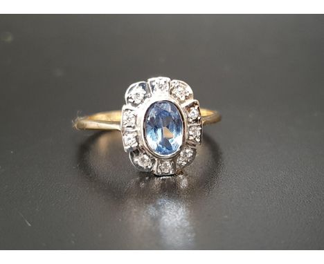 BLUE TOPAZ AND DIAMOND CLUSTER RINGthe central bezel set oval cut blue topaz approximately 0.7cts, in ten diamond surround, o