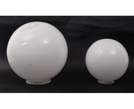 A pair of vintage late 20th century milk glass spherical graduating light shades. Each light having a globe shaped shade with