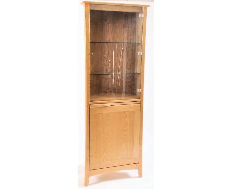 Ercol - A contemporary light oak glazed corner cabinet - cupboard. The cabinet having a single door glazed top revealing a gl