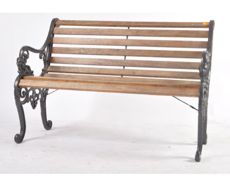 A 20th century garden / pub bench. The bench having black painted frame with lion masks to the handles with teak wood slats. 