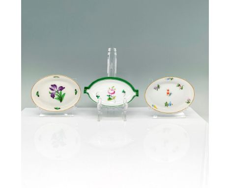 A set of three white oval dishes. Two of the dishes are completely round with gold borders and floral paintings in the interi