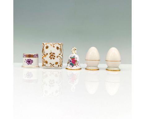 A set of 5 white porcelain items that have gold painted trims with some that have floral designs that consist of 2 seasoning 