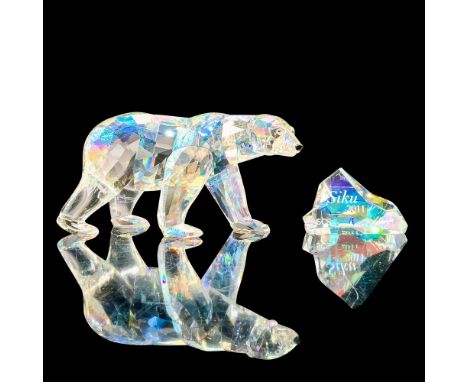 A clear crystal figure of a polar bear standing on all fours with black crystal used for the eyes and snout along with a plaq