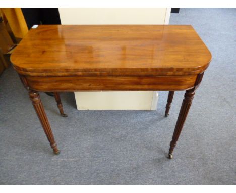 A William IV mahogany fold over card table, with reeded legs to brass casters 87 cm W 