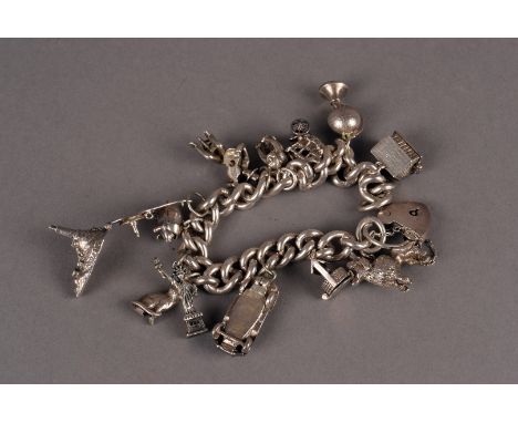 A silver charm bracelet, the curb link bracelet with heart clasp and containing 13 charms, including a car, wishing well, glo