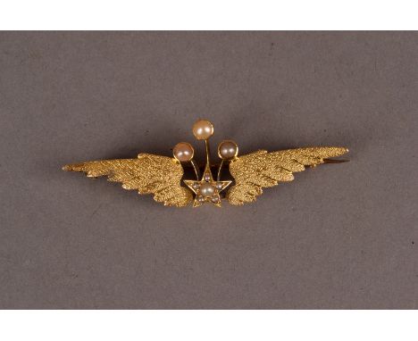 A vintage gold and seed pearl brooch, having a pair of textured wings and centred with a star and three applied stalks set wi