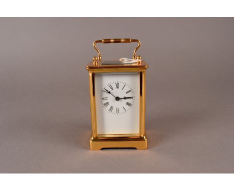 A small brass carriage clock, with white enamel Roman dial, unmarked and maker unidentified 12 cm H, presented in a larger as