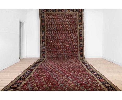 A large Persian Bidjar wool runner, first half of the 20th century, the mauve field woven with repeating paisley motifs, 692 