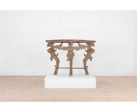 A carved pine console table, 18th century, the later moulded demilune top, over three monopodium supports, terminating in hoo