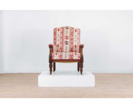 A William IV walnut armchair, early/mid-19th century, upholstered in kilim-style covering, the frame carved at the arms and r