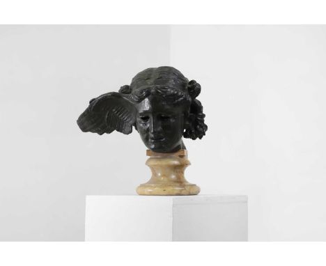 After Fernand Khnopff, a cast bronze model of the 'Head of Hypnos, God of Sleep', on a marble socle base, 38cm wide 24cm deep