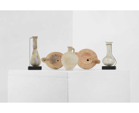 A group of five small Roman antiquities, comprising:two glass bottles, one Syrian, c.2nd-3rd century, the other c.1st-3rd cen