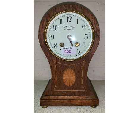 An Edwardian  inlaid oak balloon top mantel clock with striking French movement, by H Kenyon, Morley, Stockport 
