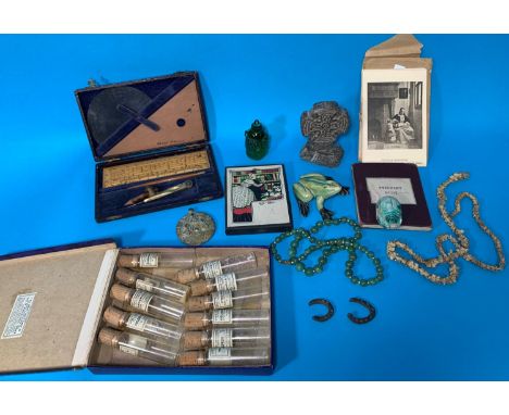 A selection of collectables:  pharmacists' vials; a jade coloured bead necklace; a Celtic stone cross; a map of the Pytchley 