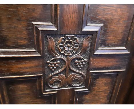 OAK BREAKFRONT BOOKCASE with carved decoration and on bun feet 110cm high, 182cm wide, 37cm deep One octagonal pane of glass 