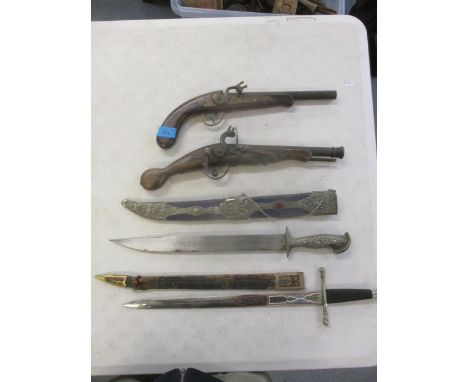 Two reproduction flintlock pistols, a 20th century Serbian dagger and scabbard and a Spanish dagger and leather scabbardLocat