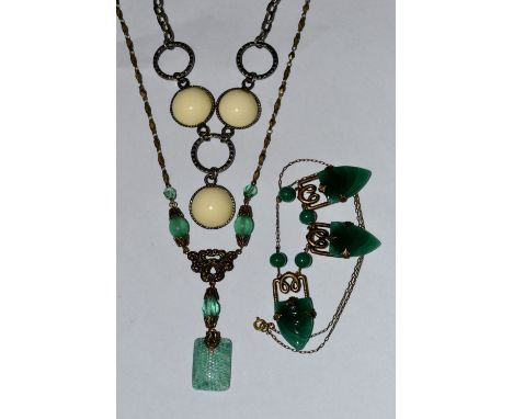 An Art Deco jade green glass necklace, composed of three sinuous scrolling panels, each inset with a green jade glass arrow h