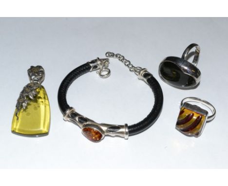 A silver mounted amber and black leather bracelet, oval amber panel arched tubular surround, sprung clasp, stamped 925;  a pe