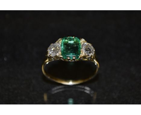 An emerald and diamond trilogy ring, central cushion cut Columbian emerald, 1.70ct, flanked to either side by a round brillia