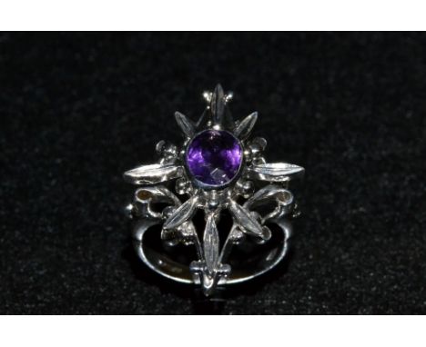 A Gothic dress ring, eight point platform crest inset with a single central oval amethyst, 9ct white gold mount and shank, st