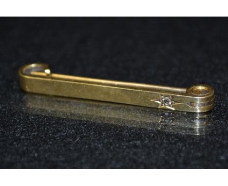A diamond and gold tie pin, round cut diamond, inset within  a six point star surround, rounded bar platform, 18ct gold body,