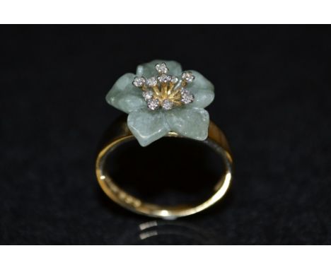 A Jade green stone and white sapphire flower ring, carved green jade floral crest, inset with eleven stamen mounted white sap