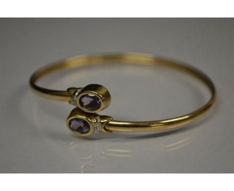 An amethyst and diamond bracelet, each overlapping terminal inset with a single oval pale purple amethyst and diamond accent,