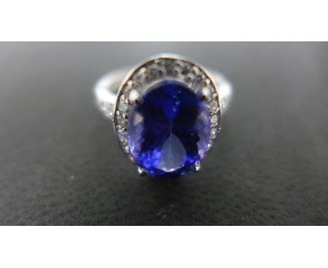 A 950 platinum diamond ring with oval cut tanzanite to shoulder, size O, approx 4.4 grams - light scratches and usage wear 