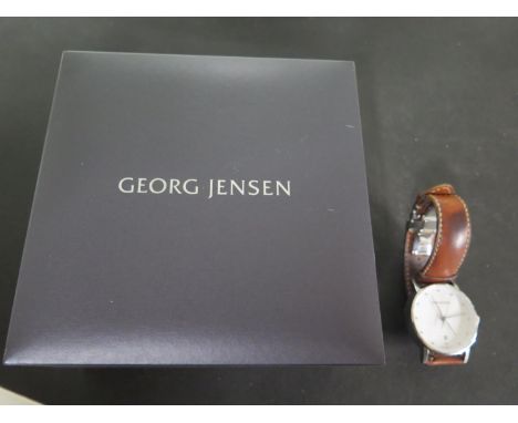 A Henning Kopel dual time Georg Jensen watch, white enamel dial, date aperture at 6 O'clock, dot hour markers, centre sweep s