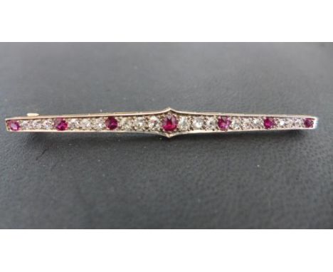 A ruby and diamond bar brooch - the diamonds in 6 groups of 3, interspersed with 7 rubies - in general good condition, approx