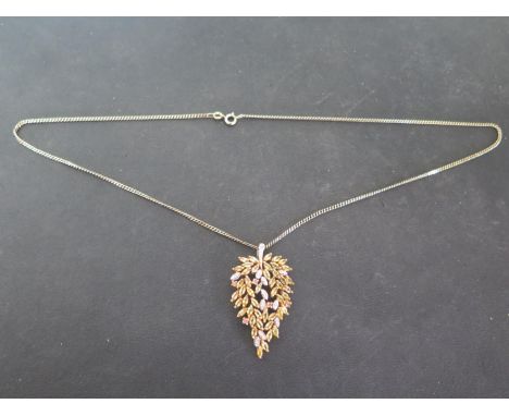 A 9ct yellow gold foliate form pendant set with yellow sapphires and diamonds on a 9ct yellow gold chain, length 52cm, approx
