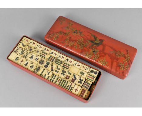 An Early/Mid 20th Century Chinese Mahjong Game, The Bone and Wood Tiles Housed in a Lacquered Rectangular Box, Lid Decorated 