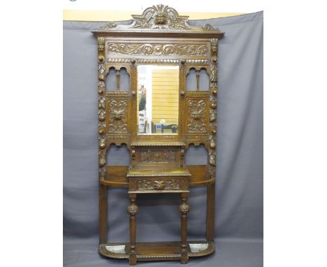 CIRCA 1900 CARVED OAK HALL STAND with mask and fruit detail, central glove drawer and base shelf with trays, 221cms overall H