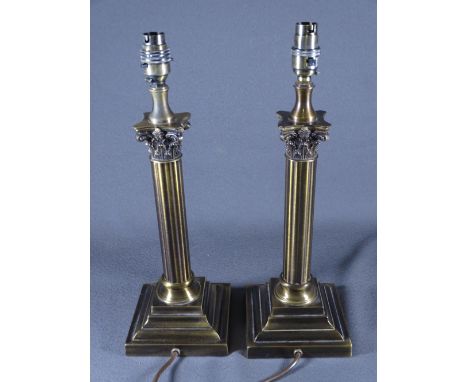 PAIR OF BRASS EFFECT TABLE LAMPS with Corinthian style columns on a step base E/T