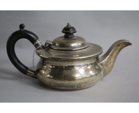 A 1920's small silver teapot, of squat circular form, with ebonised handle and finial, gross 14.5 oz.
