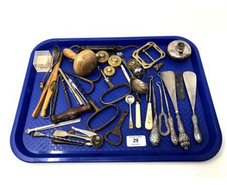 A tray containing vintage corkscrews, silver handled shoe horns and button hooks, cutlery, brass weights, Mauchline ware glov