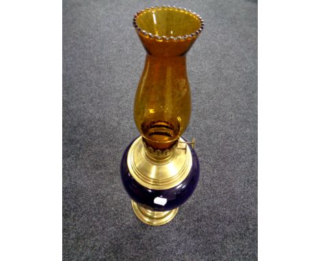 A Duplex brass and porcelain oil lamp with amber glass chimney 