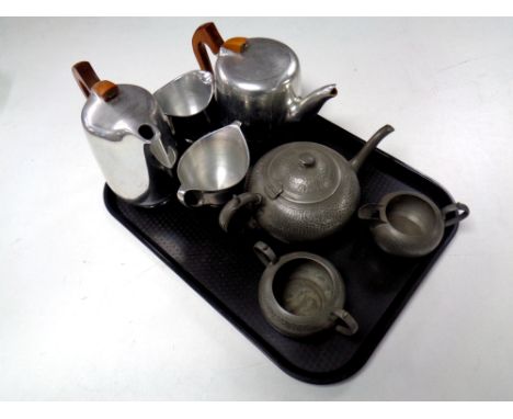 A three piece English pewter tea service and four piece Piquot ware tea service 