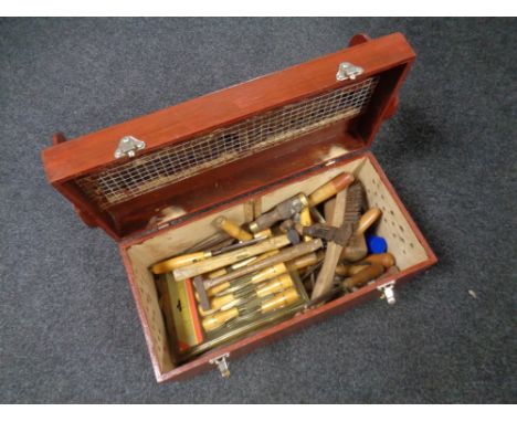 A wooden tool box containing vintage hand tools to include chisel sets, hammers, miniature garden tools etc. 