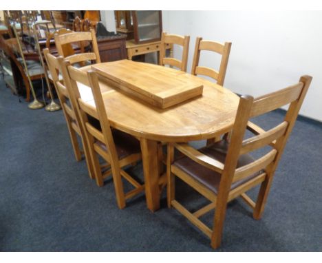 A good quality contemporary oak oval extending table with two leaves together with a set of six ladder backed chairs 