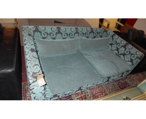 A contemporary designer two seater sofa upholstered in blue foliate patterned fabric