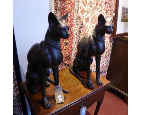 A pair of large Egyptian style bronze figures of cats seated on their hind legs 