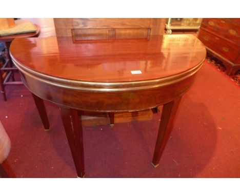 A French mahogany demi lune and gilt metal bound card table the foldover top raised on square tapering supports