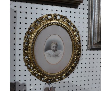 A 19th century hand tinted print portrait of a child in a good 19th century giltwood frame with scrolling pierced floral bord