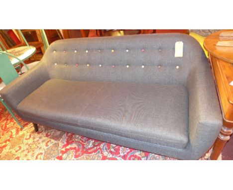 A contemporary vintage style two seater sofa in dark blue fabric with polychrome button back, raised on tapering ebonised sup