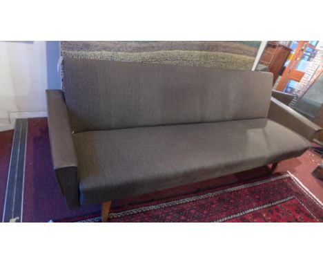 A 20th century designer three seater sofa upholstered in brown fabric 