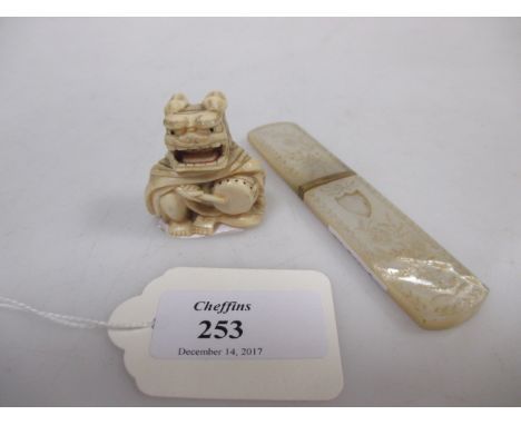 A small Japanese netsuke, A small gilt mounted mother of pearl needle case  