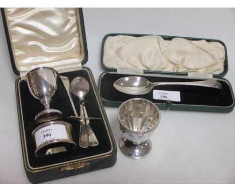 A silver egg cup, napkin ring and spoon, Birmingham 1938 & 1939, cased, and another silver egg spoon and pusher, an egg cup, 