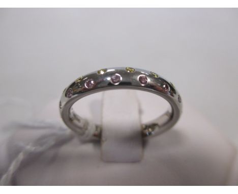 A fancy pale pink and fancy pale yellow diamond platinum eternity ring, the small round brilliant cut diamonds spaced around 