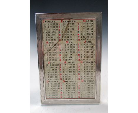 A small silver mounted perpetual calendar,by J C Vickery, London 1913, the rectangular frame with engine turned decoration co